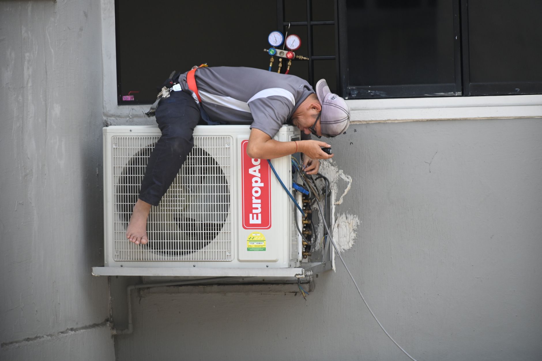 Technician installing air conditioner
